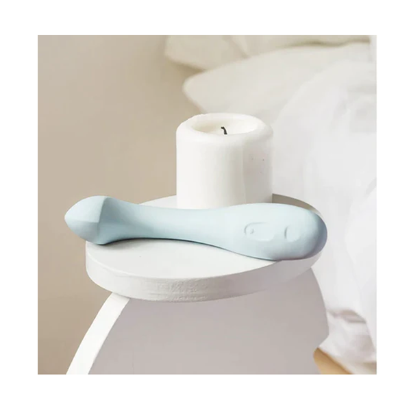 Arc - Ice sex toy next to a candle on a nightstand.