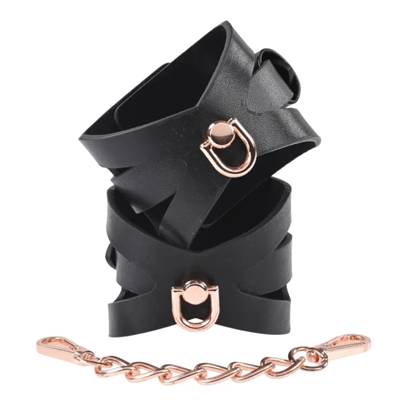 Brat Handcuffs in black faux leather with rose gold chain for playful restraint in adult toys.
