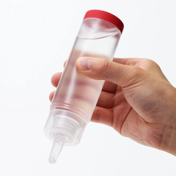 Hand holding Tenga lotion Mild, a thick, long-lasting water-based lotion for enhanced pleasure with sex toys.